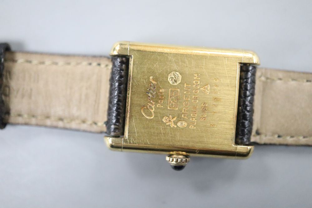 A ladys 925 gilt Must De Cartier manual wind wrist watch, with rectangular black Roman dial, on Cartier strap,